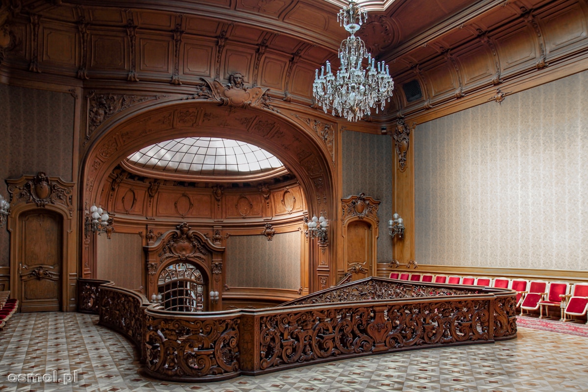 A na górze schodów Kasyna Szlacheckiego we Lwowie pięknie rzeźbiona balustrada. Nad wszystkim wisi żyrandol, który dopełnia scenerii.