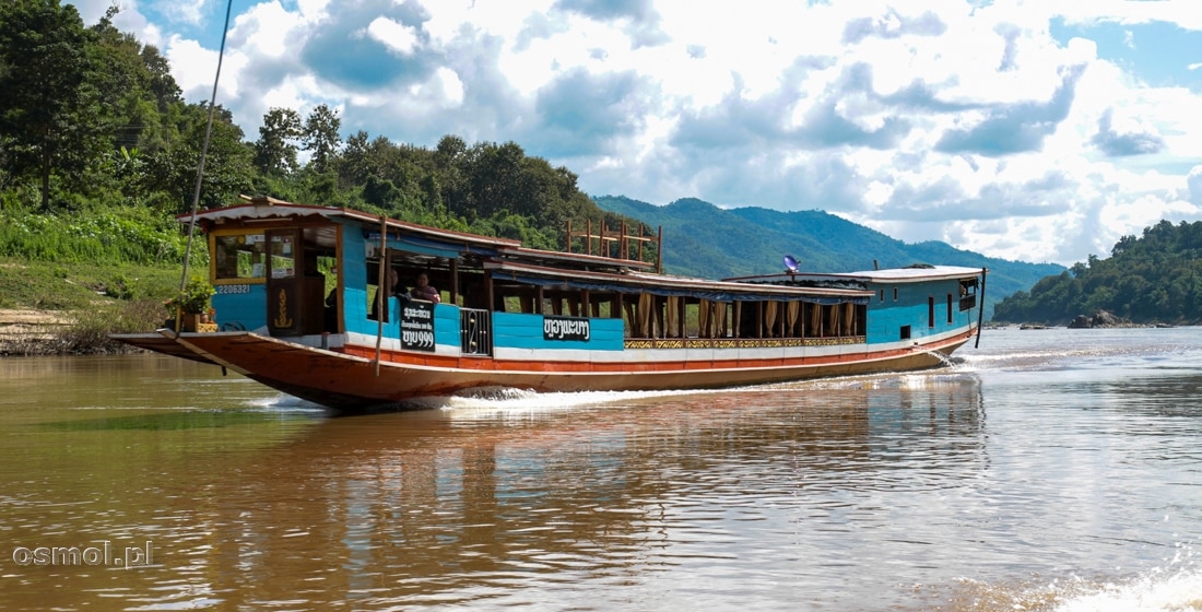 Łódź płynie w górę Mekongu, zabrać kolejnych turystów, chcących odpocząć podczas rejsu. Jak widać podczas rejsów w górę rzeki, łodzie są praktycznie puste.