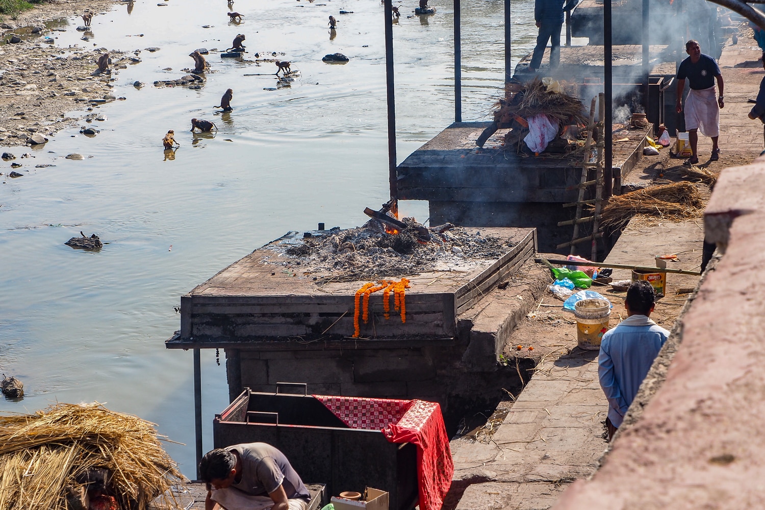 Dymiące stosy pogrzebowe w Kathmandu. Kiedy jedne gasną, a ciało uległo już spopieleniu, inne dopiero zajmują się ogniem.