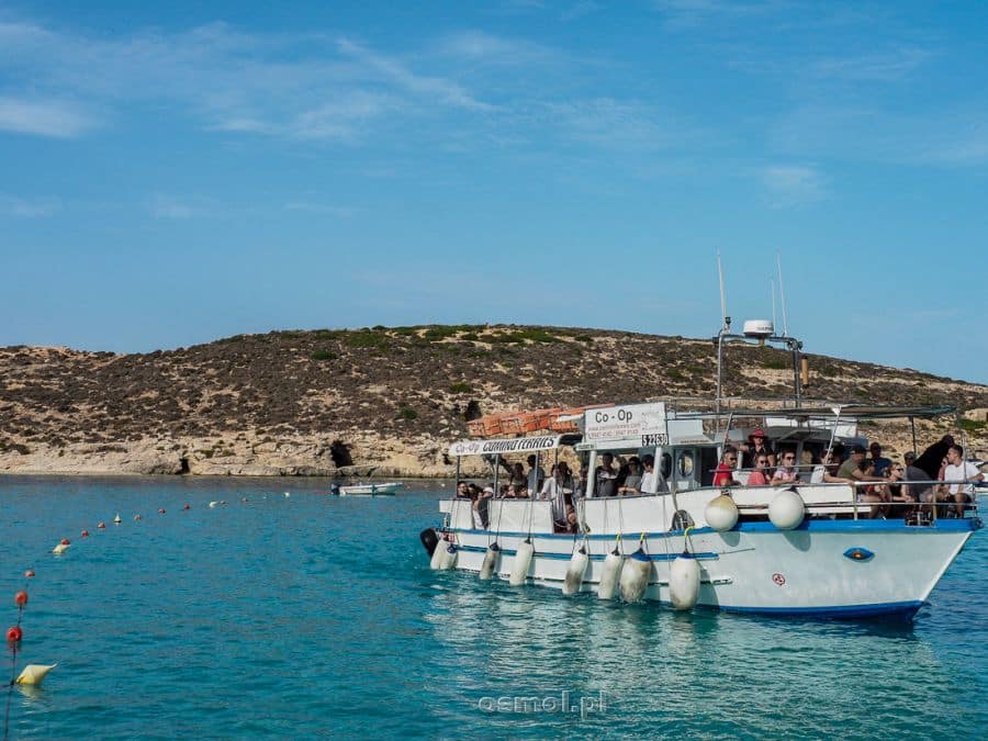 Statek z turystami przybija do nabrzeża Comino. Codziennie dziesiątki takich łodzi dopływają do tej małej wysepki.