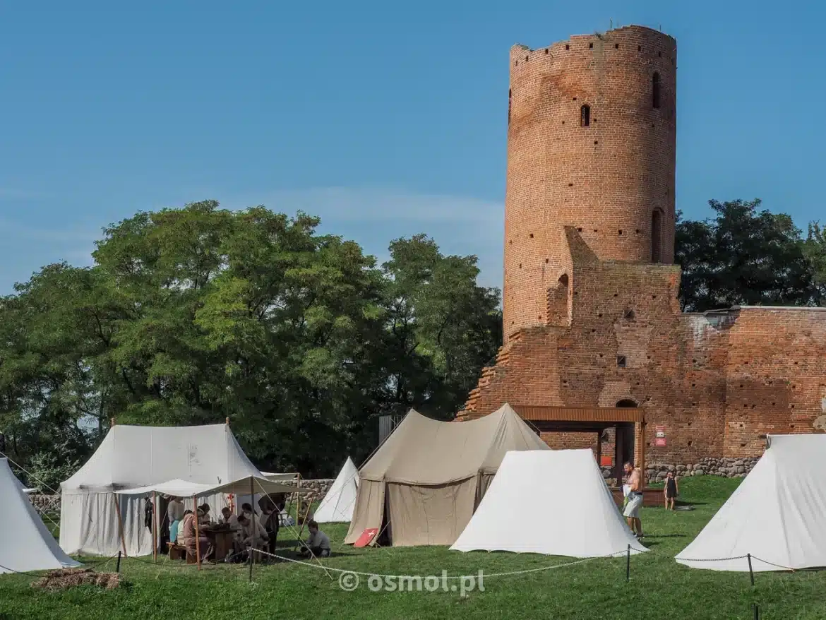 Wieża obronna zamku w Czersku na tle namiotów grupy rekonstrukcyjnej
